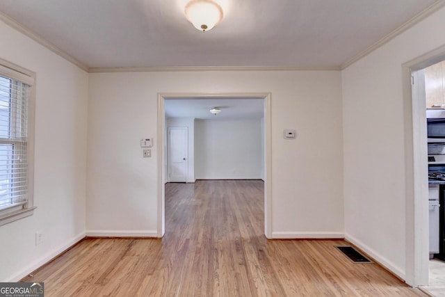 unfurnished dining area with light wood-style floors, visible vents, crown molding, and baseboards