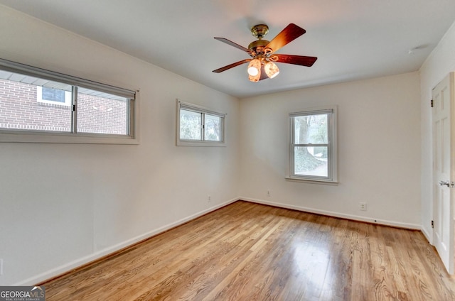 empty room with light wood finished floors, plenty of natural light, baseboards, and ceiling fan