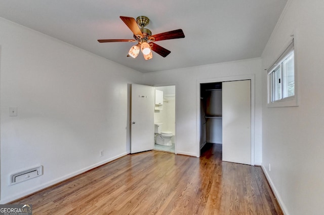 unfurnished bedroom with a closet, ceiling fan, ensuite bath, light wood-type flooring, and baseboards