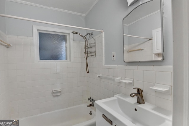 bathroom with crown molding, bathtub / shower combination, tile walls, and a sink