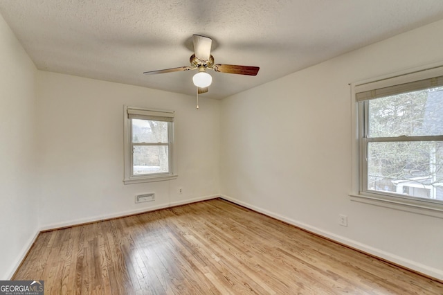 unfurnished room with light wood-style flooring, baseboards, ceiling fan, and a textured ceiling