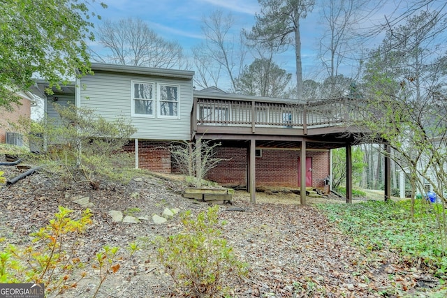 rear view of house featuring a deck and brick siding