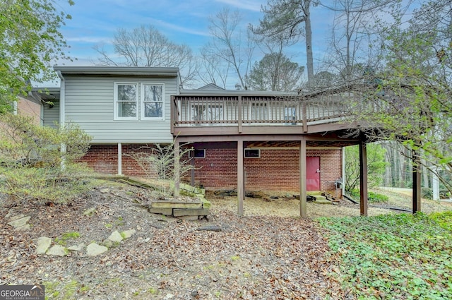 back of property featuring brick siding and a deck