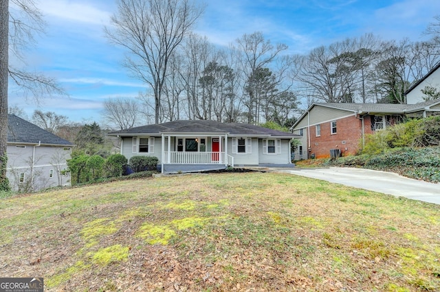 ranch-style home with covered porch, driveway, and a front yard