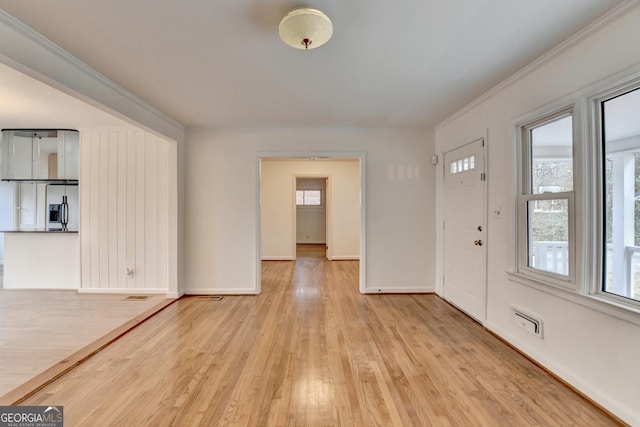 foyer with ornamental molding, light wood finished floors, and baseboards