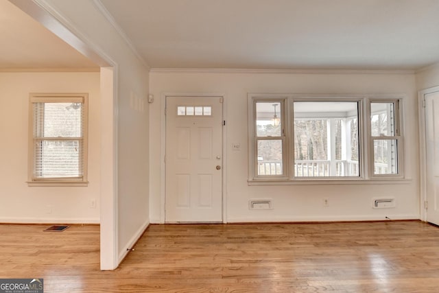 foyer entrance featuring light wood-type flooring, visible vents, and crown molding