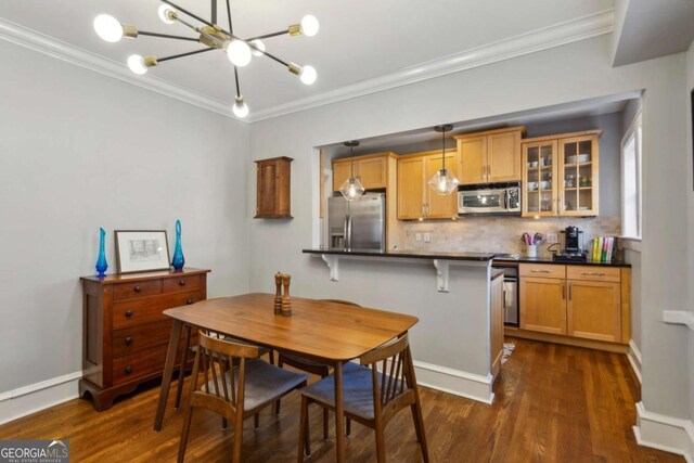 dining space with an inviting chandelier, baseboards, ornamental molding, and dark wood-type flooring