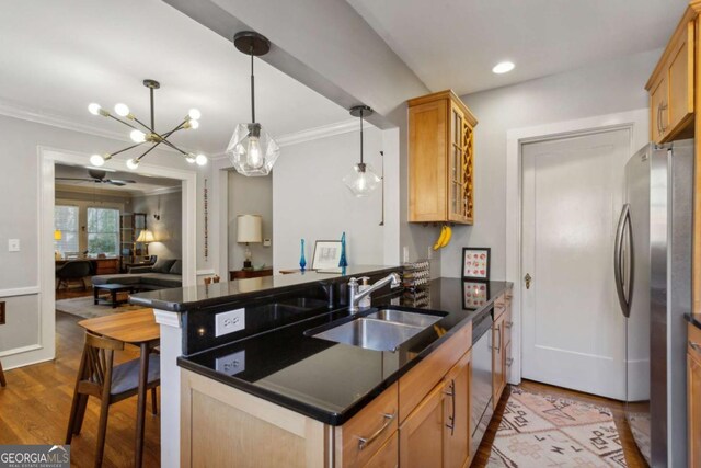 kitchen featuring appliances with stainless steel finishes, dark countertops, a sink, and a peninsula