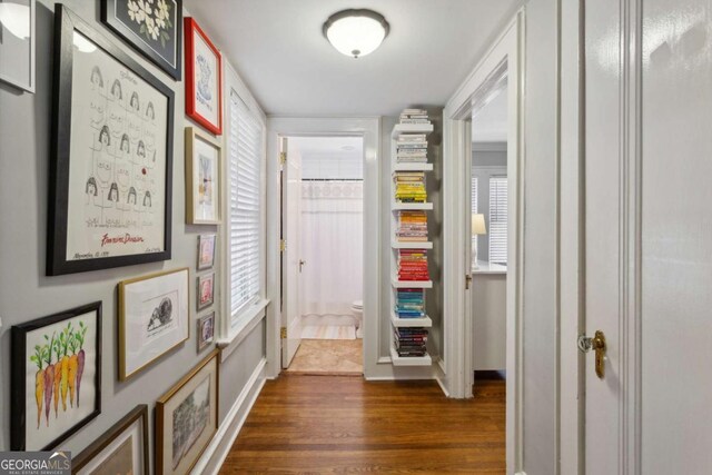 hall with dark wood-style floors and baseboards