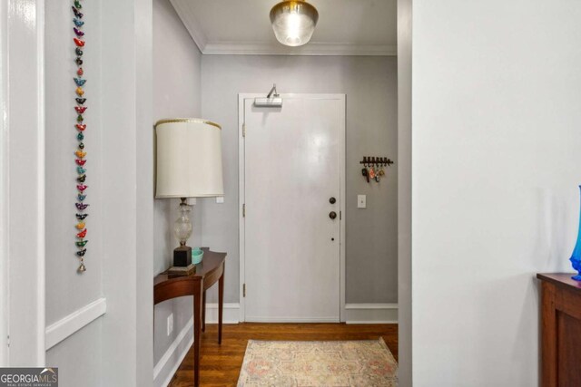 entryway featuring baseboards, ornamental molding, and dark wood-type flooring