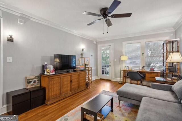 living area with ornamental molding, light wood finished floors, a ceiling fan, and baseboards