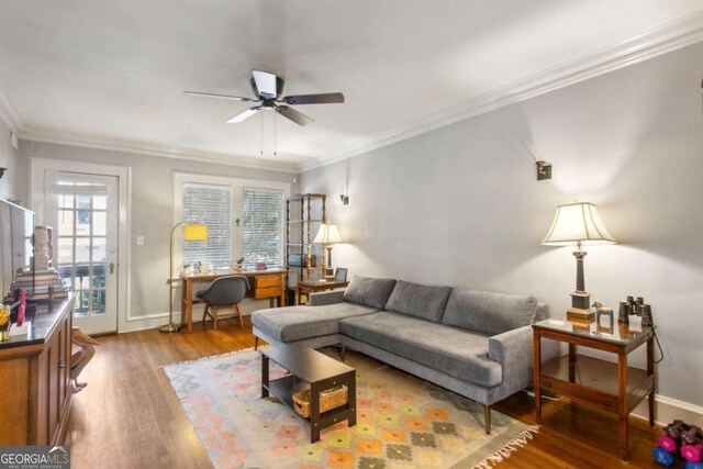 living room featuring a ceiling fan, baseboards, ornamental molding, and wood finished floors