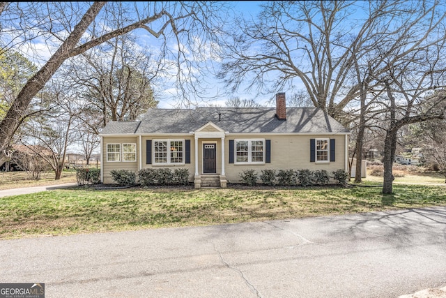 view of front of home with a front yard and a chimney