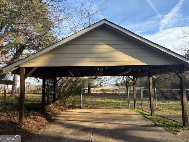 view of property's community with fence and a detached carport