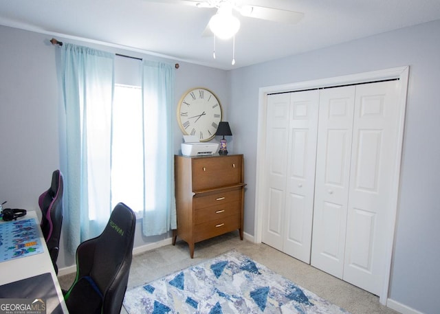 office featuring light carpet, a ceiling fan, and baseboards