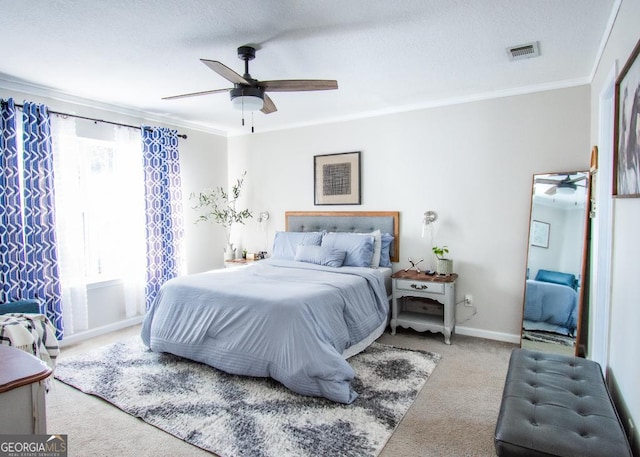 bedroom with baseboards, visible vents, carpet, a textured ceiling, and crown molding