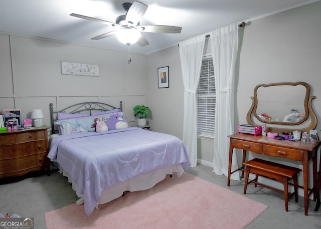 carpeted bedroom featuring ornamental molding and a ceiling fan