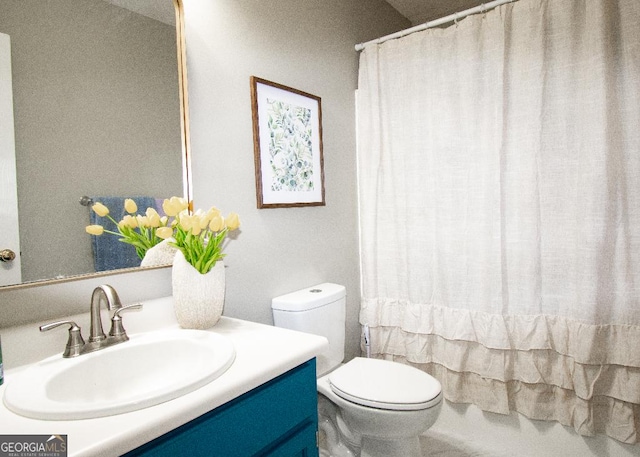 bathroom featuring toilet, vanity, and a shower with curtain