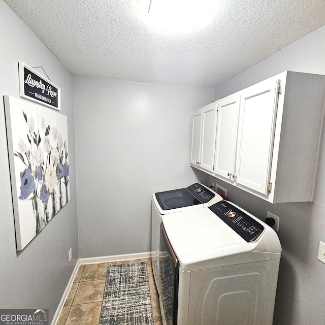 clothes washing area with a textured ceiling, independent washer and dryer, cabinet space, and baseboards