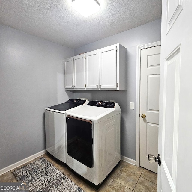 laundry room with cabinet space, light tile patterned floors, baseboards, a textured ceiling, and washer and dryer