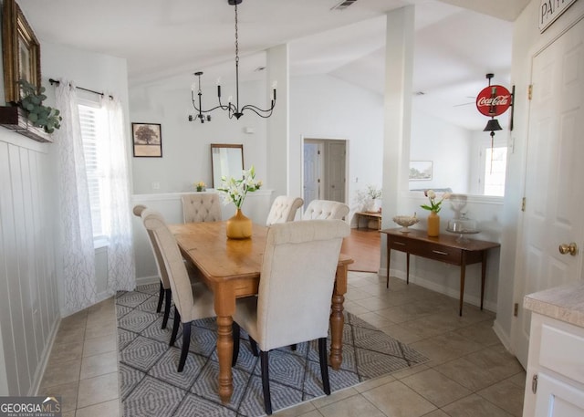 dining room with light tile patterned flooring, vaulted ceiling, visible vents, and an inviting chandelier