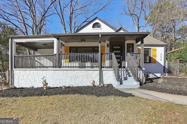 view of front of property featuring a porch, a front yard, and fence