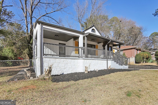 view of front of house featuring fence, a front lawn, and a porch