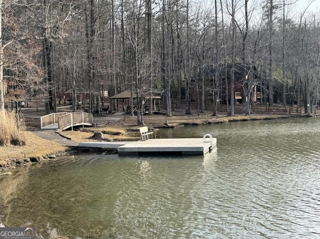 view of dock featuring a water view and a wooded view