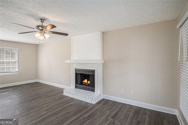 3822 Holland Dr, Snellville, GA 30039 - unfurnished living room featuring a textured ceiling, dark wood-style flooring, a fireplace, and baseboards