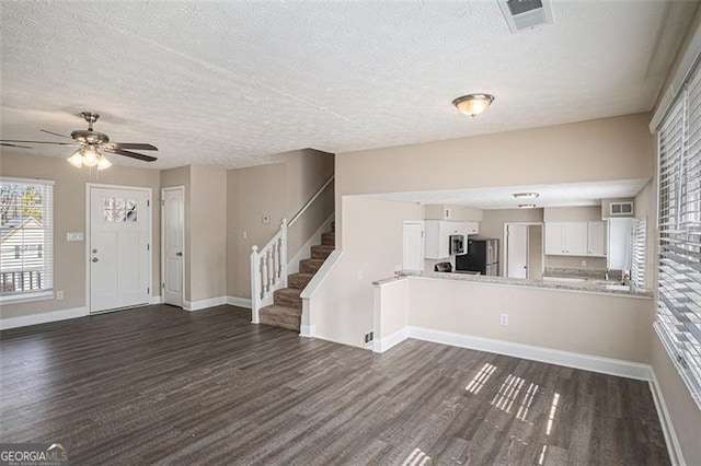 3822 Holland Dr, Snellville, GA 30039 - foyer entrance featuring baseboards, visible vents, dark wood-style flooring, stairs, and a textured ceiling