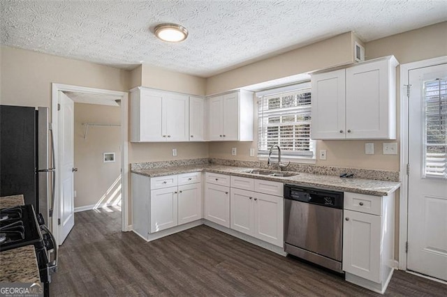 3822 Holland Dr, Snellville, GA 30039 - kitchen featuring light stone counters, a sink, white cabinets, appliances with stainless steel finishes, and dark wood finished floors