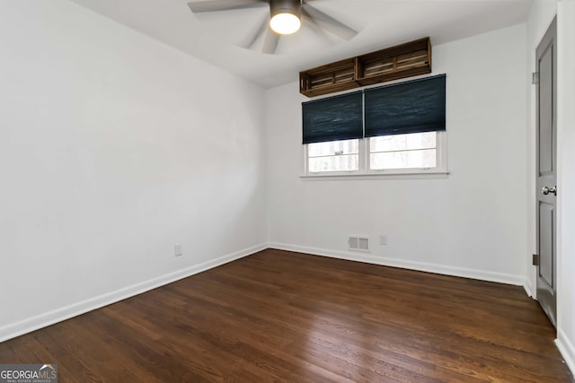 unfurnished bedroom with a ceiling fan, visible vents, dark wood finished floors, and baseboards