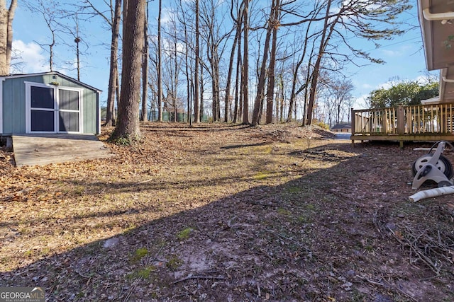 view of yard with an outbuilding, a shed, and a wooden deck