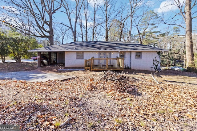 view of front of home with brick siding and a wooden deck