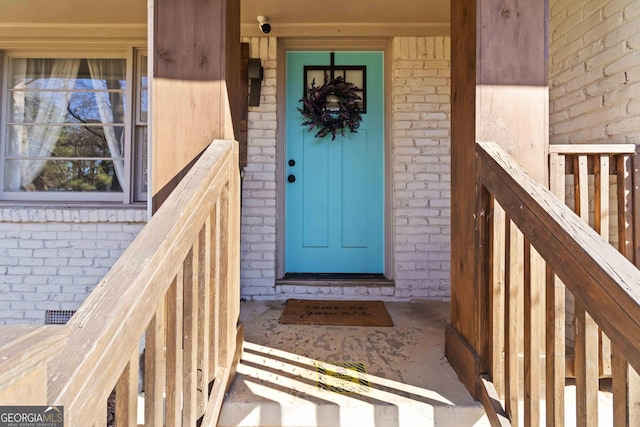 property entrance featuring brick siding