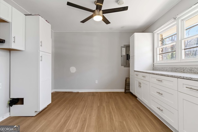 kitchen with baseboards, white cabinets, ceiling fan, light countertops, and light wood-type flooring