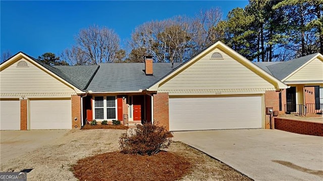 ranch-style home featuring a garage, a chimney, concrete driveway, and brick siding