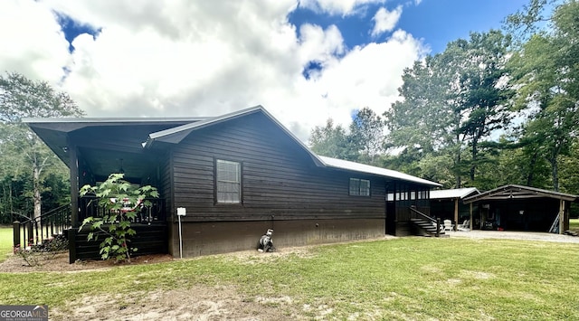 view of side of home featuring a detached carport and a yard