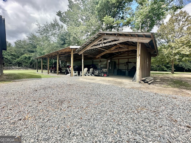 exterior space featuring a pole building, a carport, and an outdoor structure