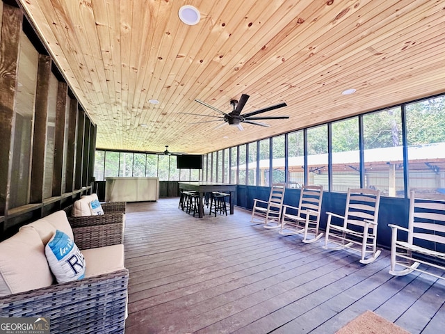 sunroom / solarium with a ceiling fan and wood ceiling