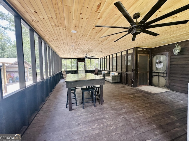 sunroom / solarium featuring wood ceiling and a ceiling fan