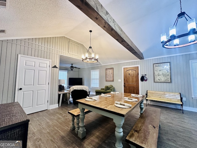 dining room with vaulted ceiling with beams, a textured ceiling, wood finished floors, and baseboards