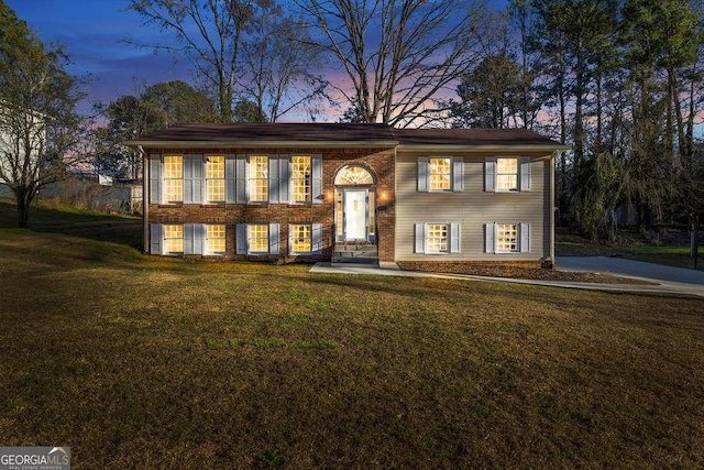 bi-level home with brick siding and a lawn