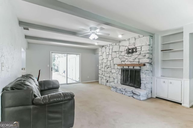 living room featuring light carpet, built in shelves, a fireplace, and beam ceiling