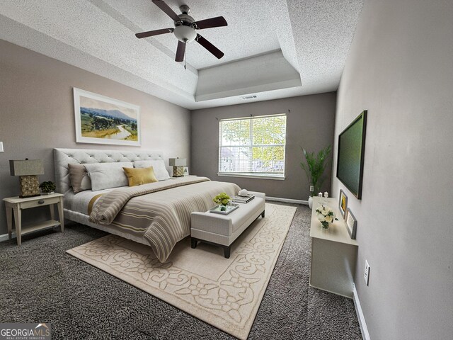 bedroom featuring a raised ceiling, a textured ceiling, and baseboards