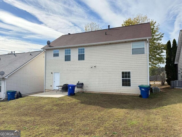 back of property featuring a patio area, a yard, and central AC