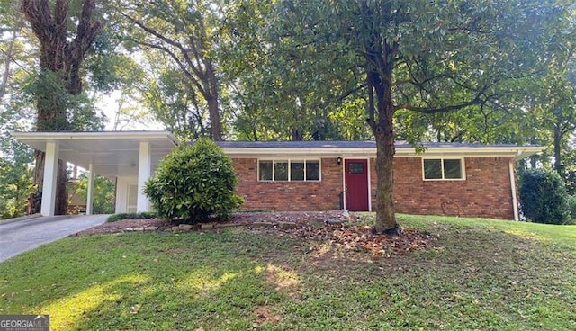 single story home with driveway, an attached carport, a front yard, and brick siding