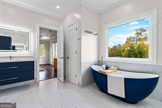 full bathroom featuring marble finish floor, recessed lighting, ornamental molding, vanity, and a freestanding tub