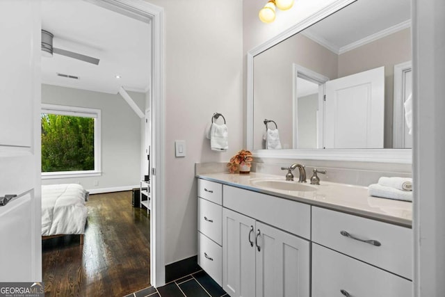 ensuite bathroom featuring visible vents, ornamental molding, wood finished floors, and vanity