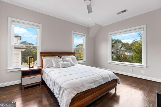 bedroom featuring baseboards, visible vents, dark wood finished floors, ceiling fan, and crown molding